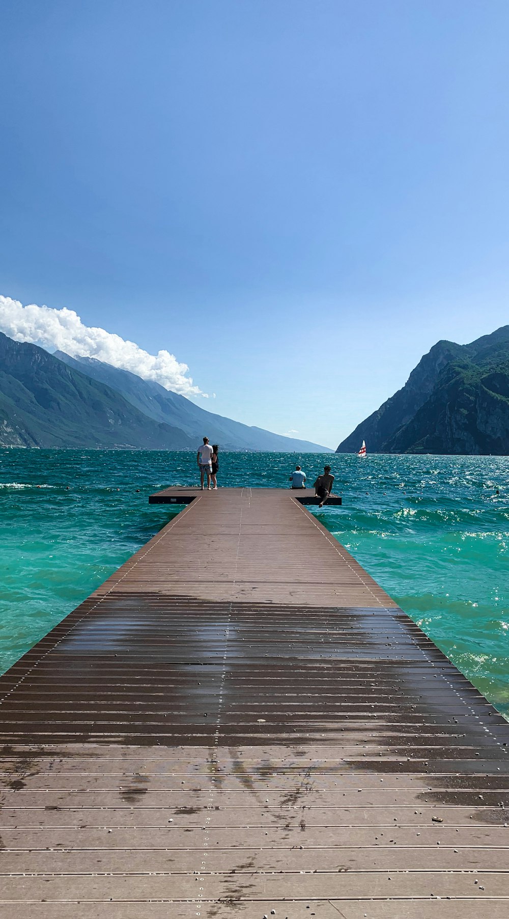 person standing on wooden dock near body of water during daytime