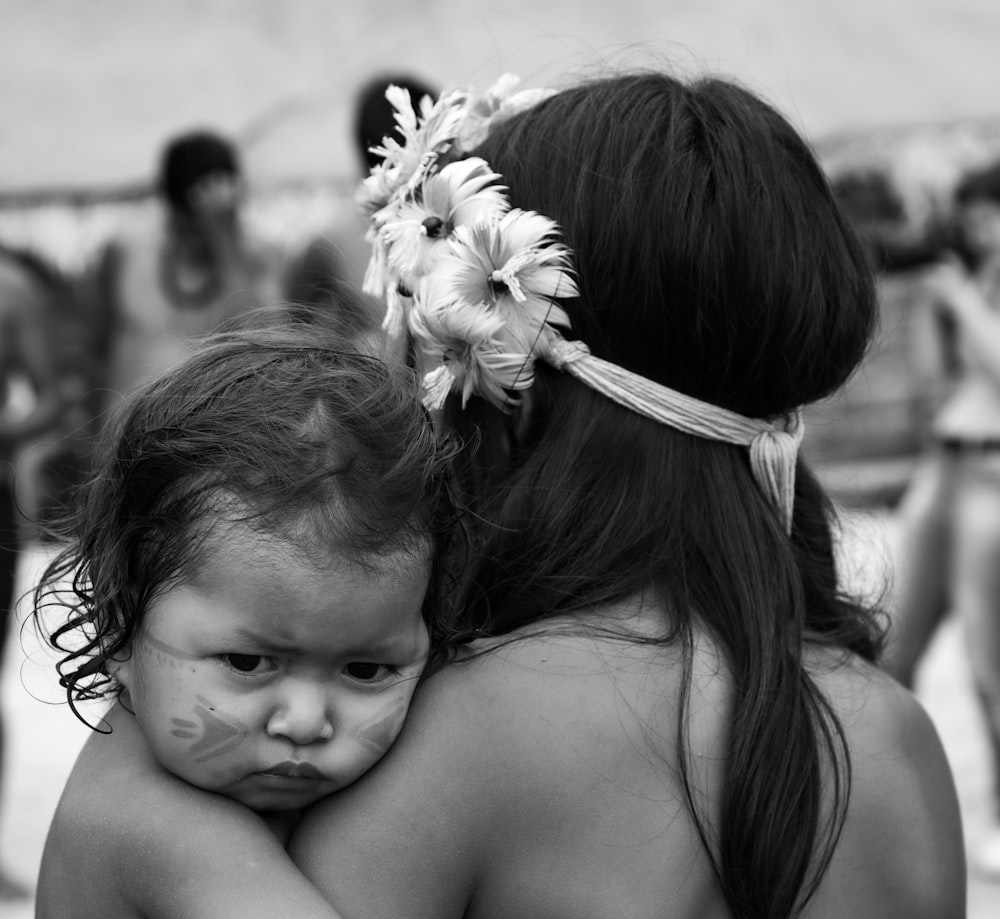 grayscale photo of woman carrying baby