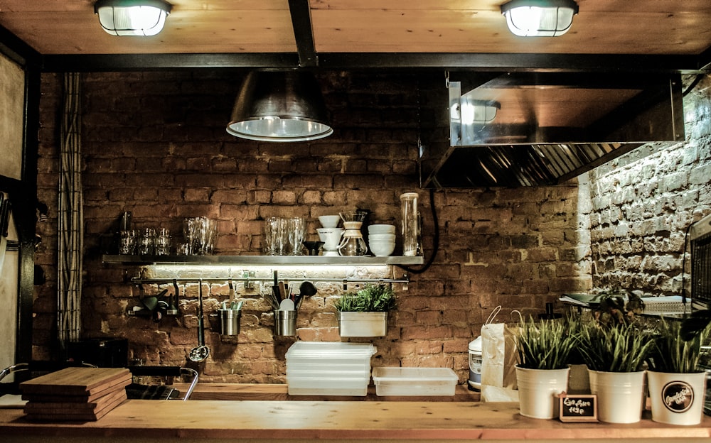 silver pendant lamps turned on above white ceramic bowls