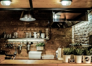 silver pendant lamps turned on above white ceramic bowls