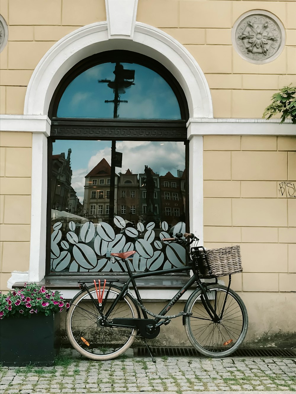 black city bike parked beside white concrete building during daytime