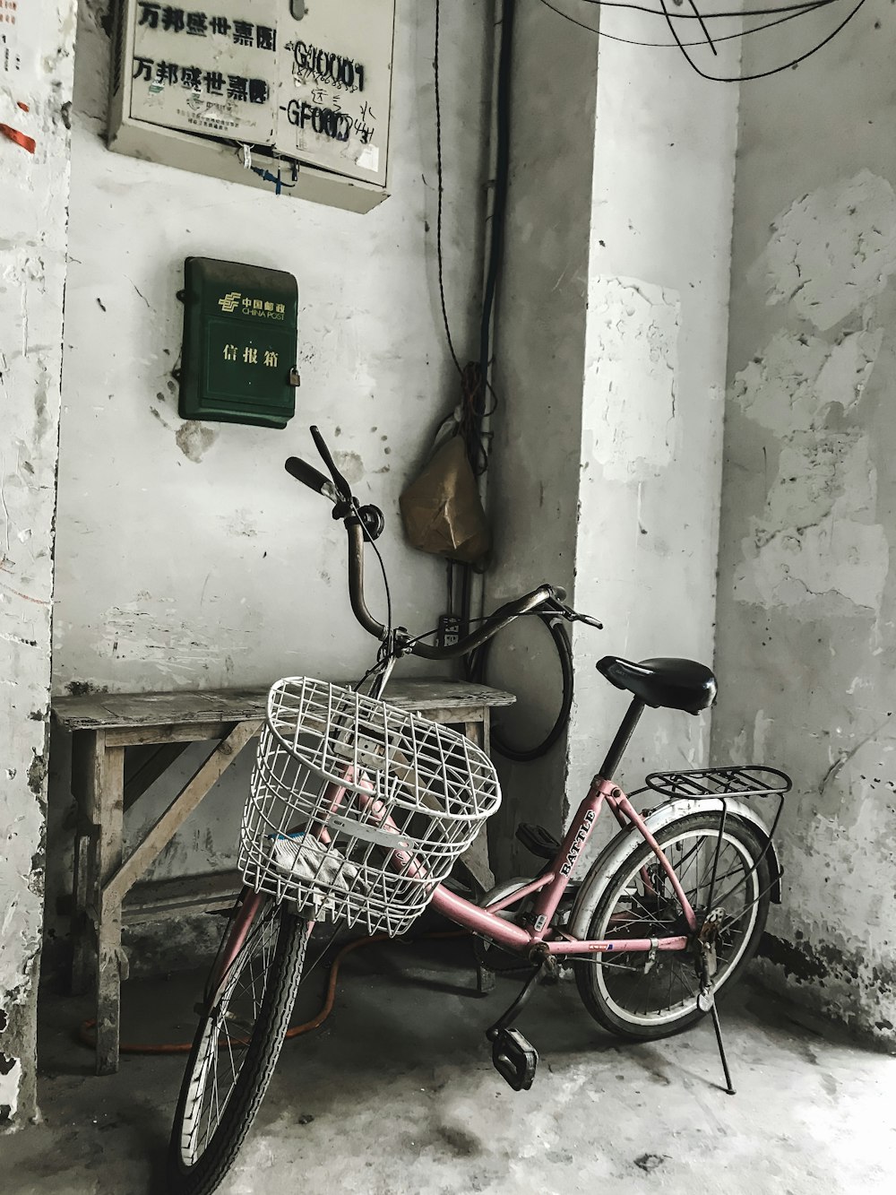 red city bike parked beside white wall