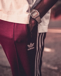 person in white shirt and red pants with black leather belt