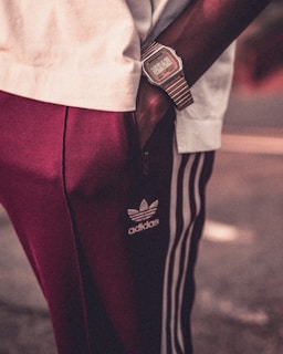 person in white shirt and red pants with black leather belt