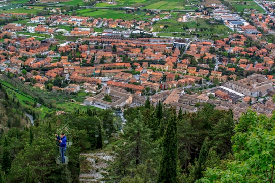 person in blue jacket standing on top of mountain during daytime in Gubbio Italy