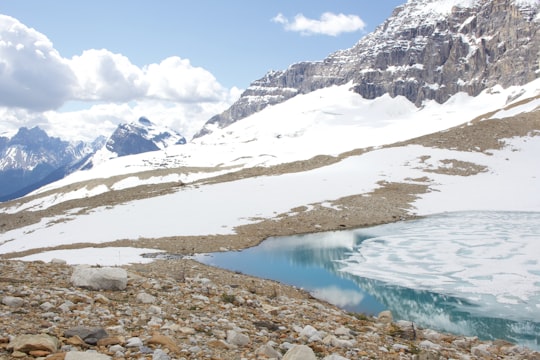 lake in the middle of snow covered mountains in Iceline Trail Canada