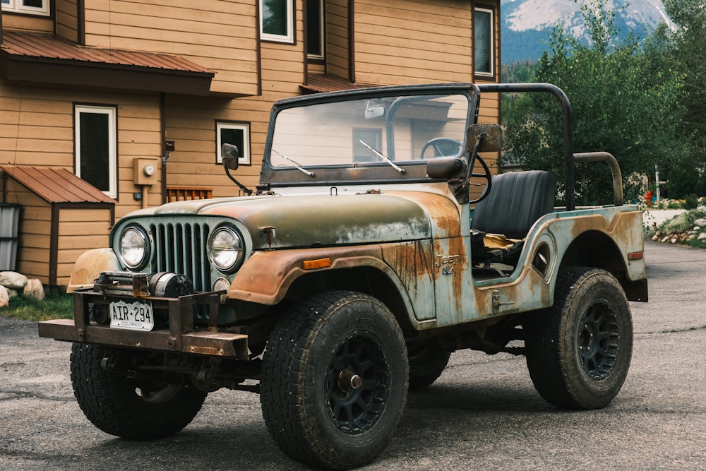 white and brown jeep wrangler parked near brown wooden house during daytime