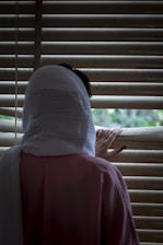 person in white shirt and red pants sitting on window