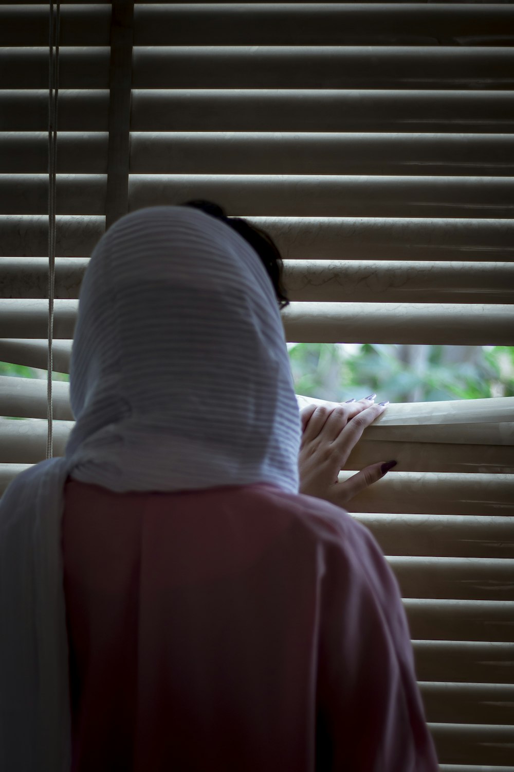 person in white shirt and red pants sitting on window