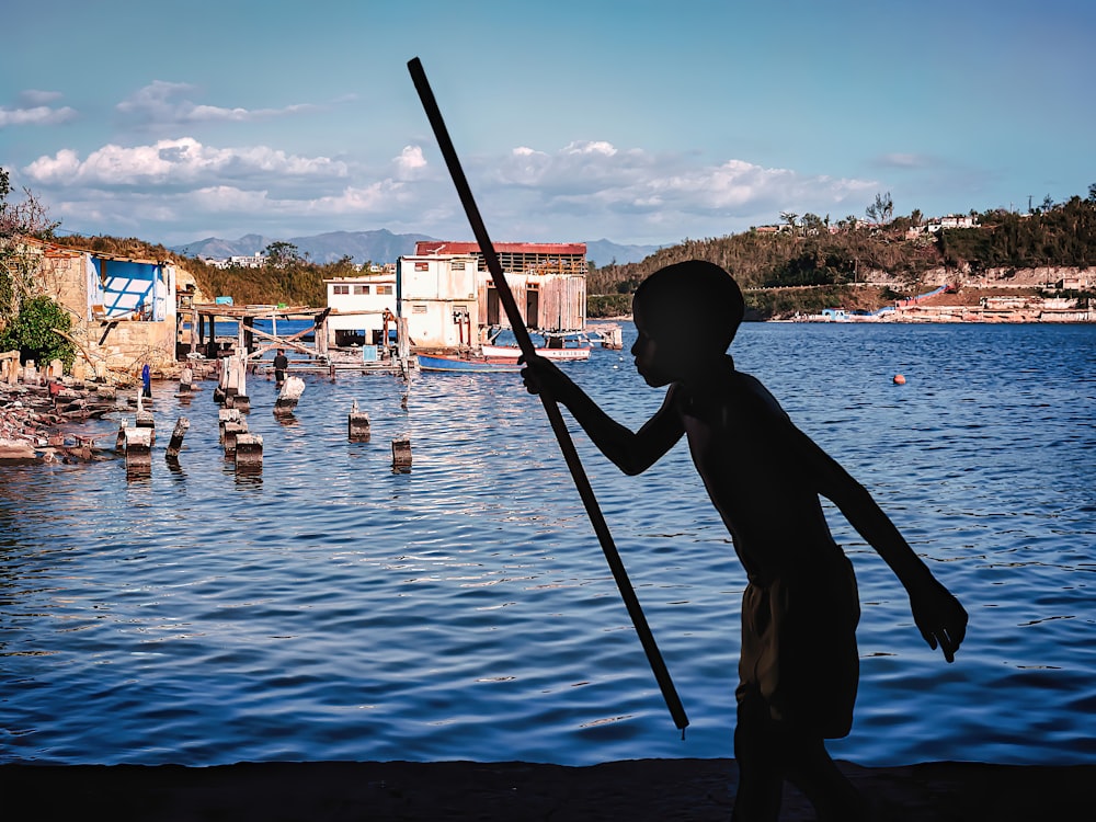 homme en chemise noire de pêche sur l’eau pendant la journée