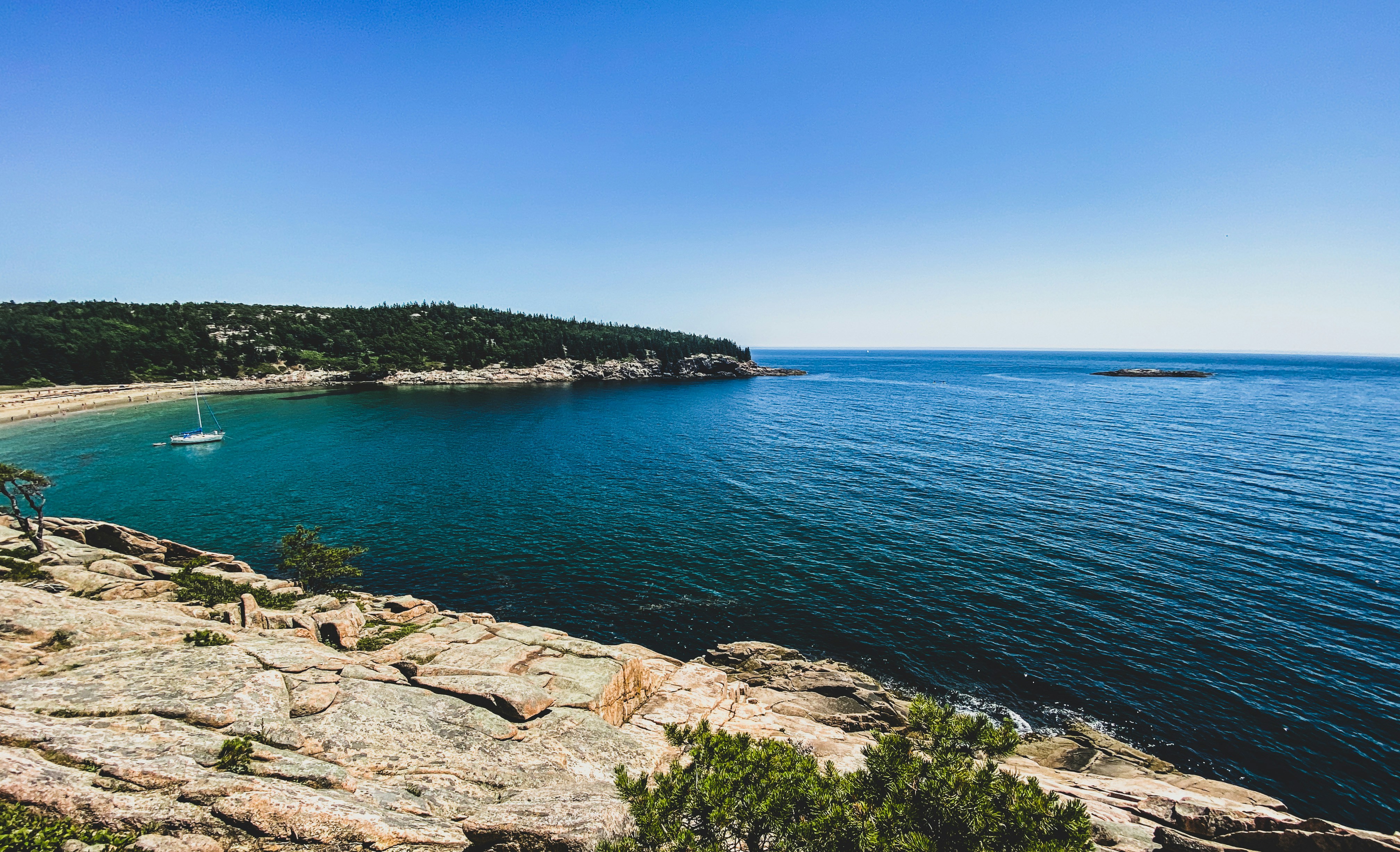 a boat is on the water near a rocky shore