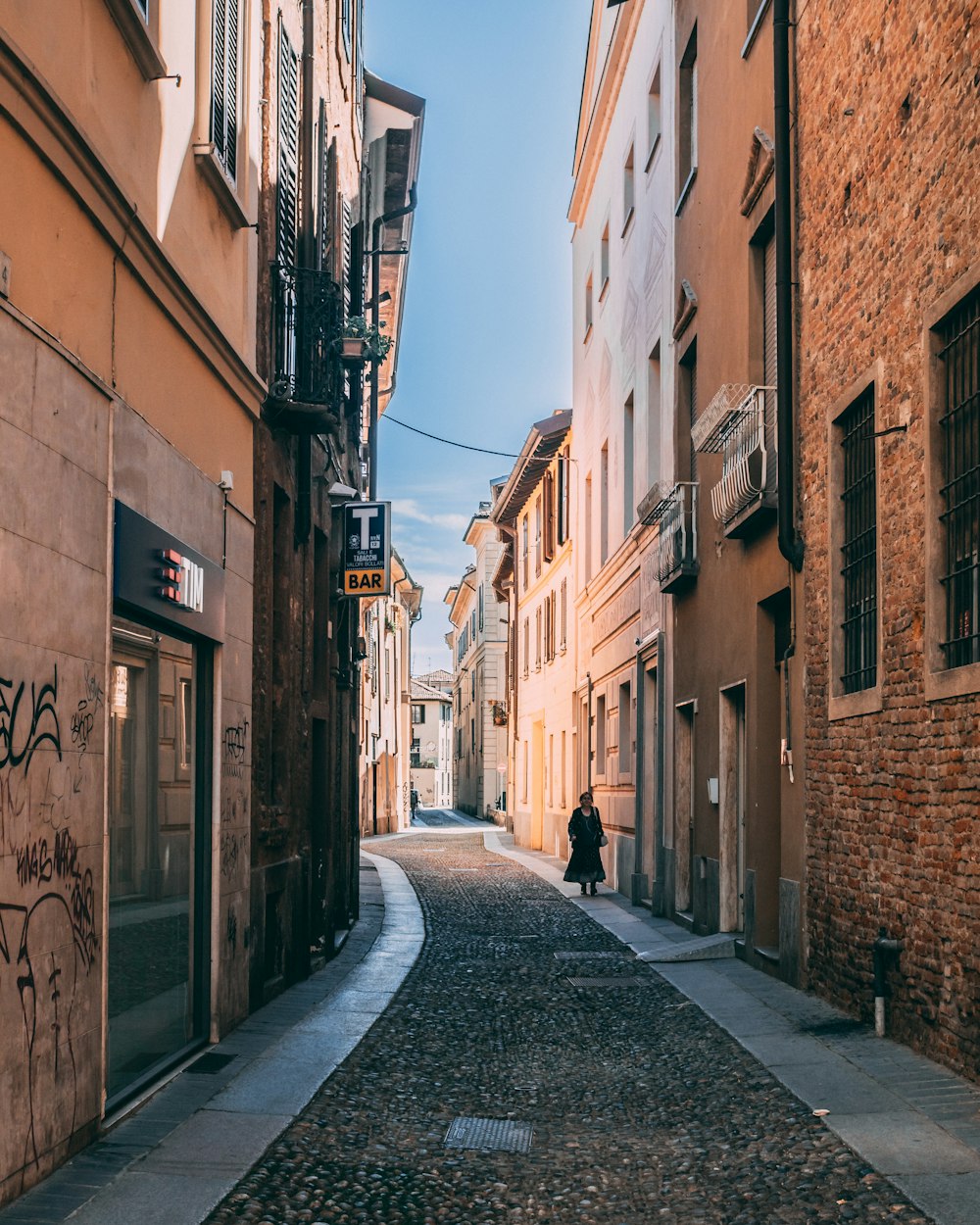 empty street between concrete buildings during daytime