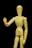 A wooden artist's mannequin is positioned against a black background. The mannequin is standing upright with one arm raised and bent at the elbow, as if gesturing or waving. The smooth, light wood of the mannequin contrasts starkly with the dark background.