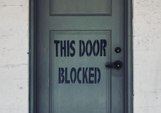 blue wooden door with white concrete wall