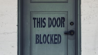 blue wooden door with white concrete wall