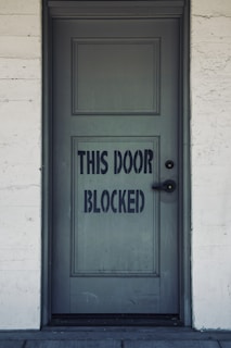 blue wooden door with white concrete wall