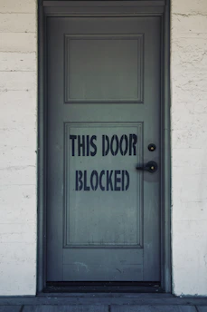 blue wooden door with white concrete wall