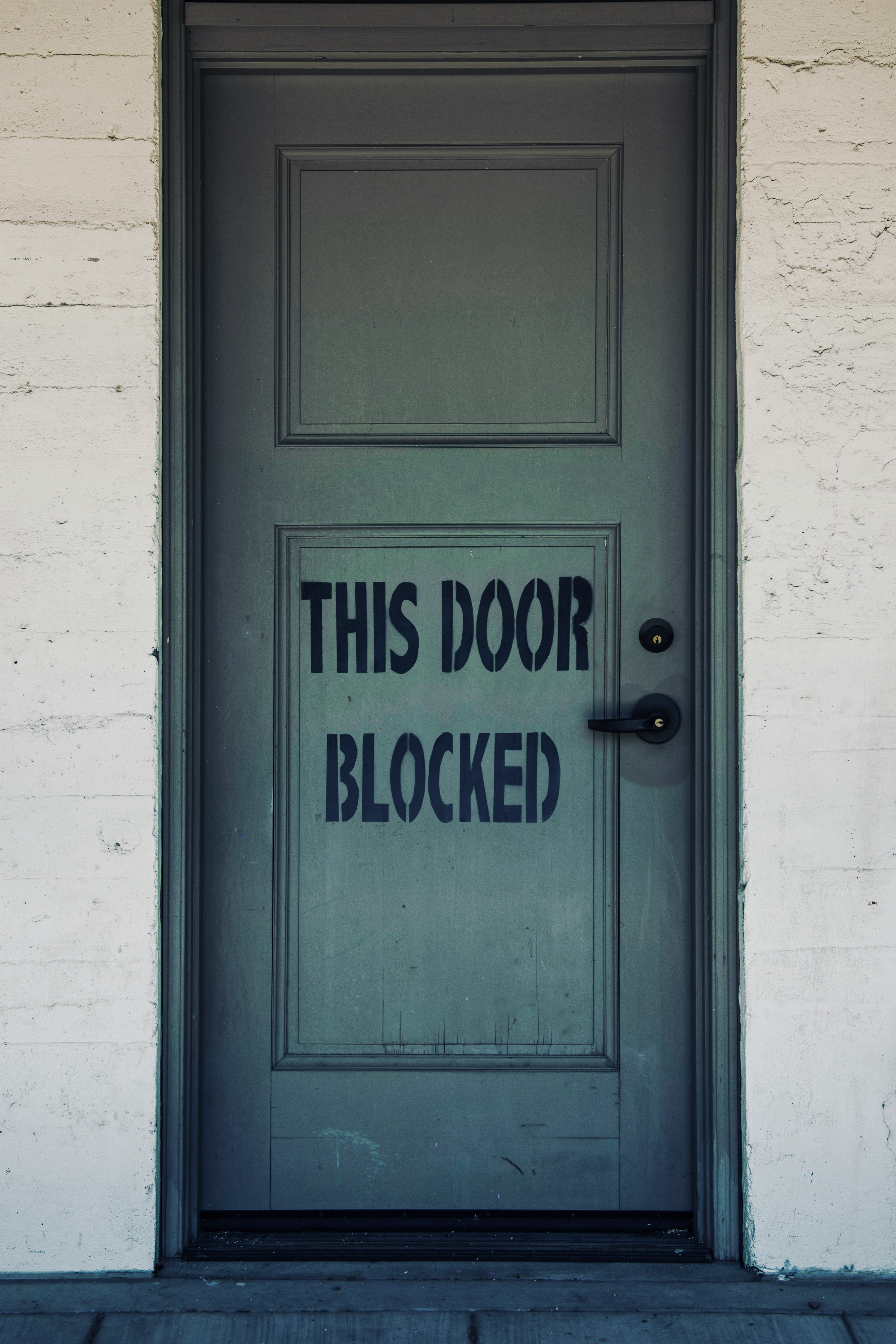 blue wooden door with white concrete wall