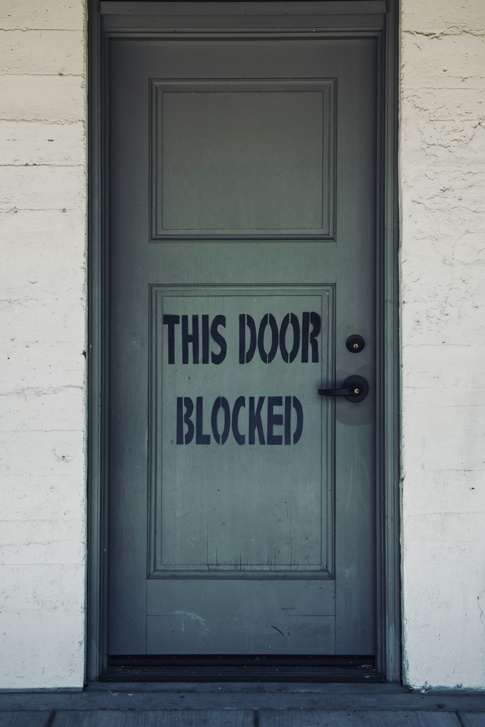 blue wooden door with white concrete wall