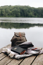 A serene sunrise over a quiet lake with an open Bible resting on a wooden dock.