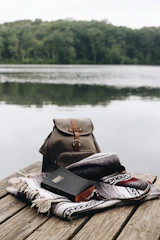 A serene lakeside scene with a journal and camera resting on a bench.