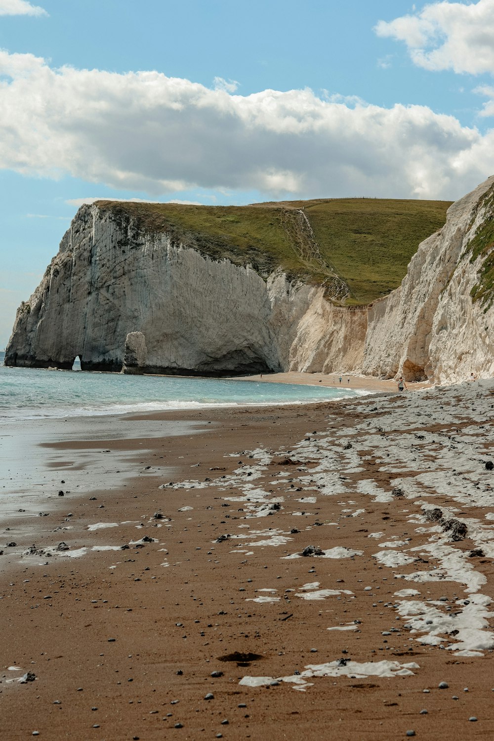 brown rock formation beside body of water during daytime