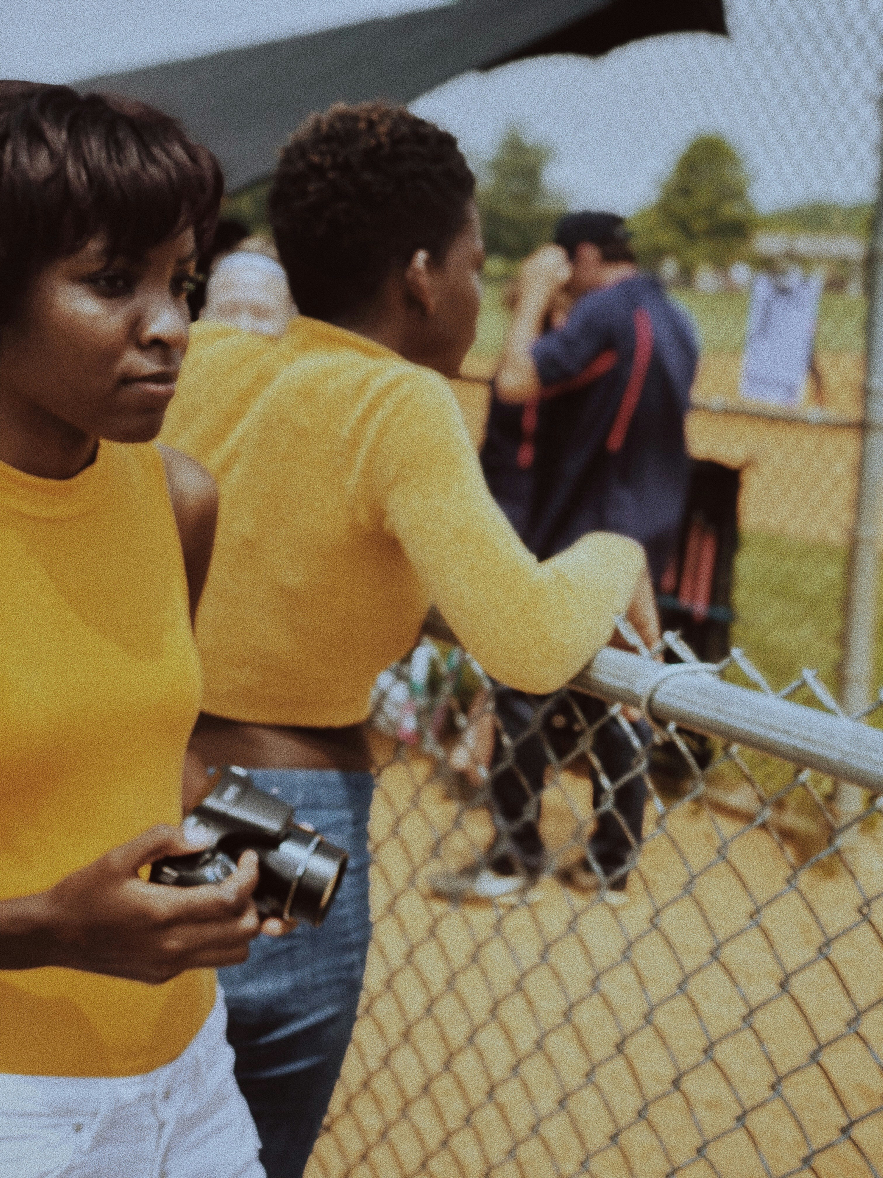 woman in yellow long sleeve shirt holding black dslr camera