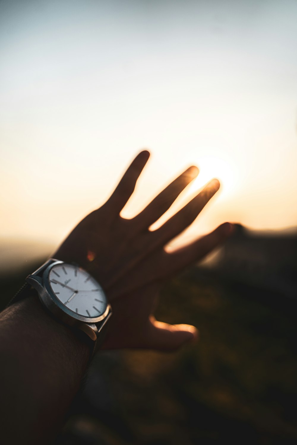 personne portant une montre analogique ronde argentée