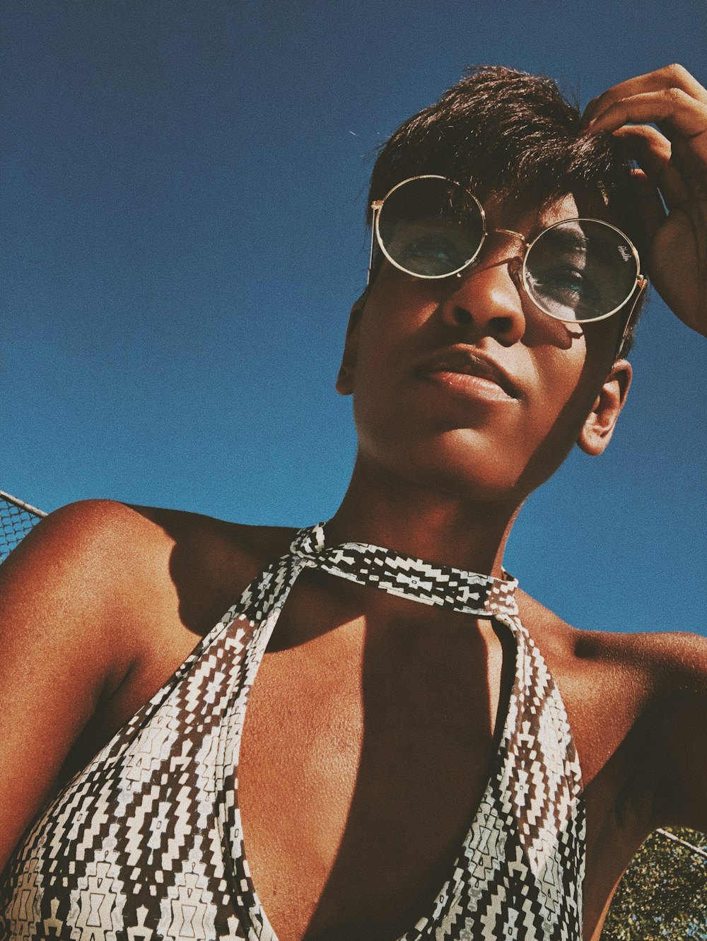 a woman wearing sunglasses and a halter top