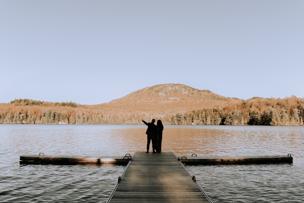 person standing on wooden dock during daytime