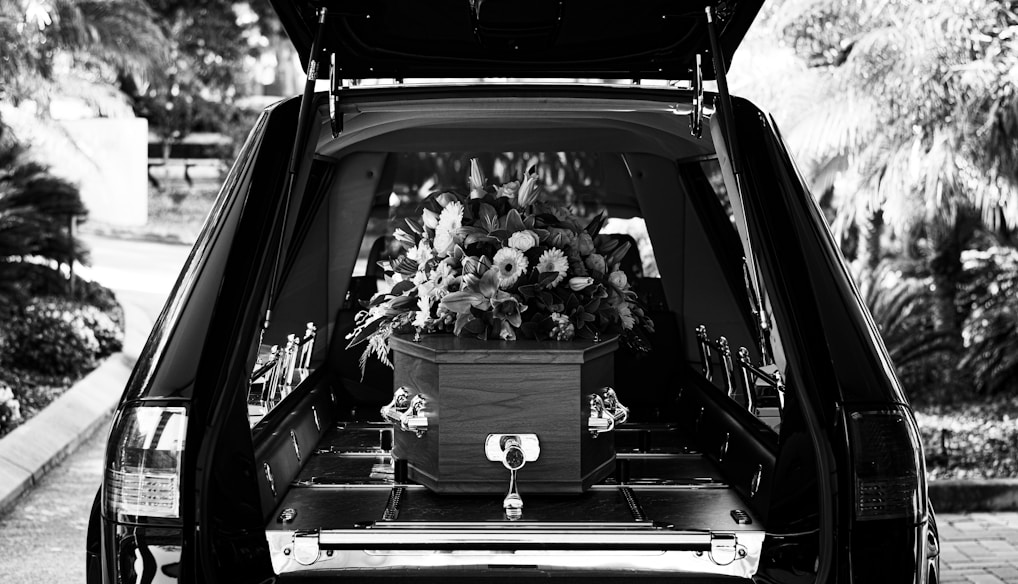 grayscale photo of car with flowers