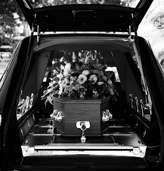 grayscale photo of car with flowers