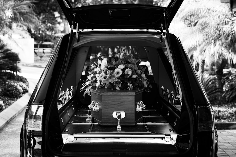 grayscale photo of car with flowers