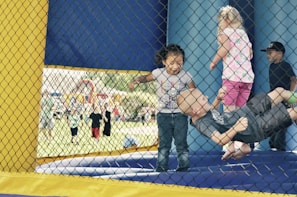 Smiling children jumping and having fun on an inflatable bounce house during a celebration.