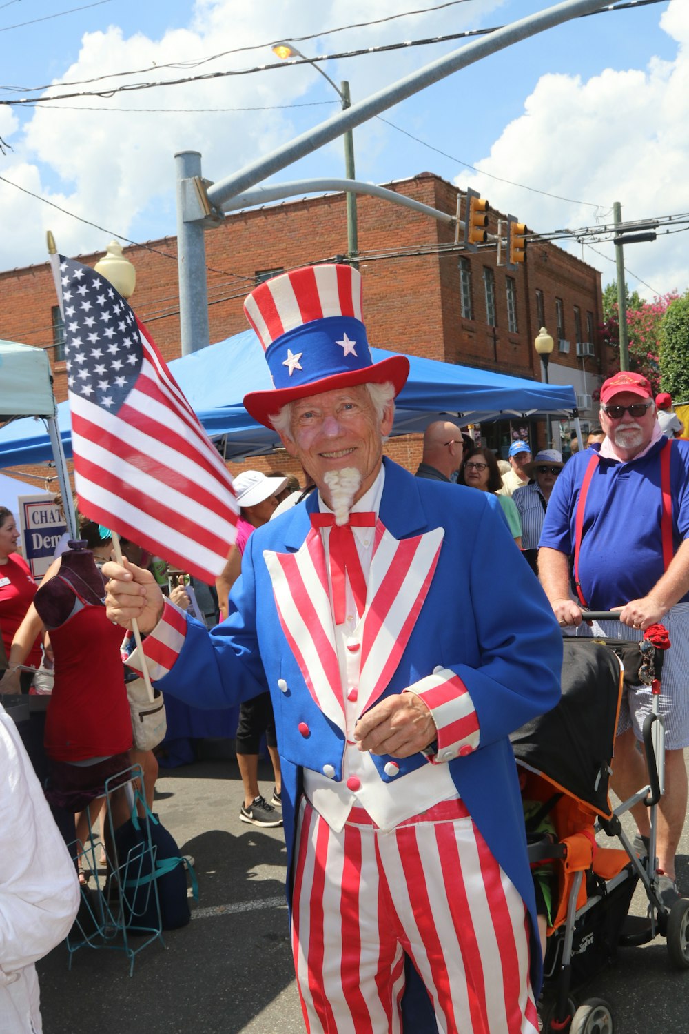 man in blue white and red striped long sleeve shirt standing near people during daytime