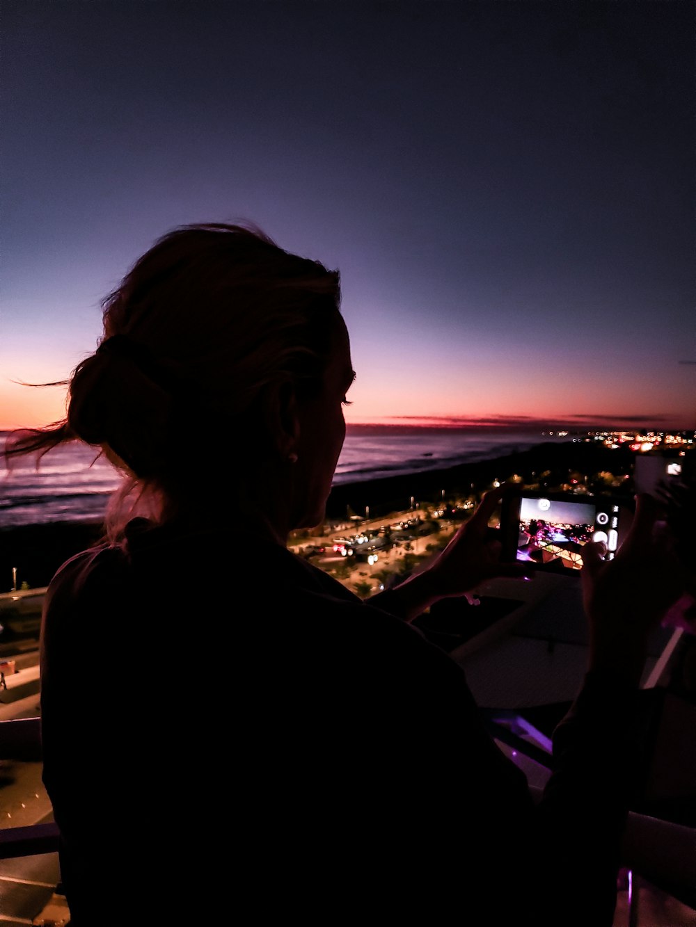 silhouette of woman standing on top of building during night time