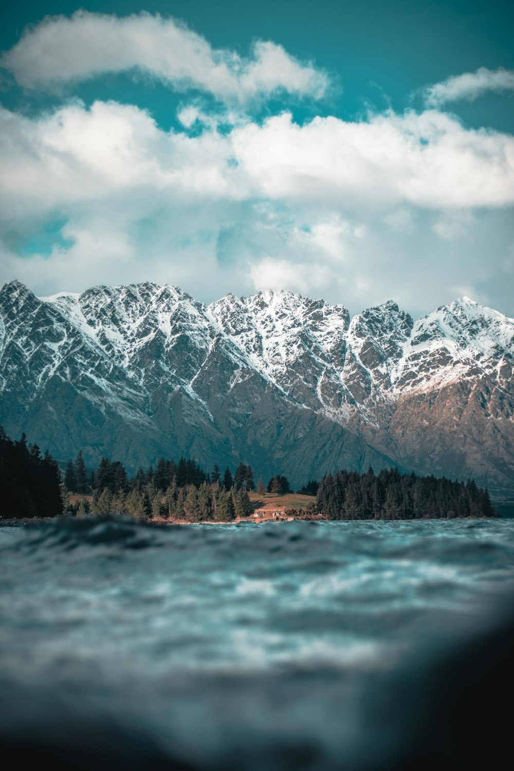 snow covered mountain near body of water during daytime