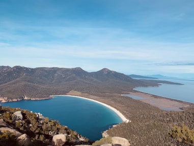 blue lake surrounded by mountains under blue sky during daytime