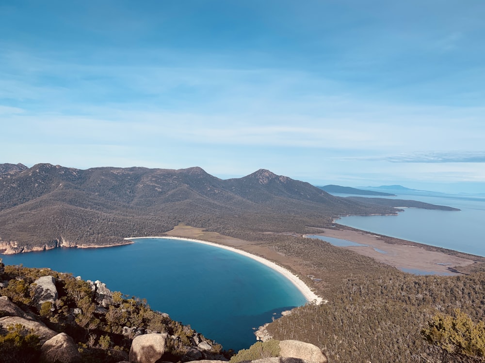 blue lake surrounded by mountains under blue sky during daytime