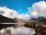 body of water near mountain under blue sky during daytime