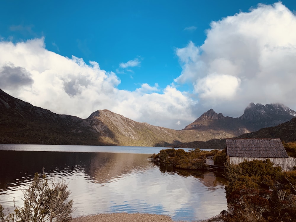 body of water near mountain under blue sky during daytime