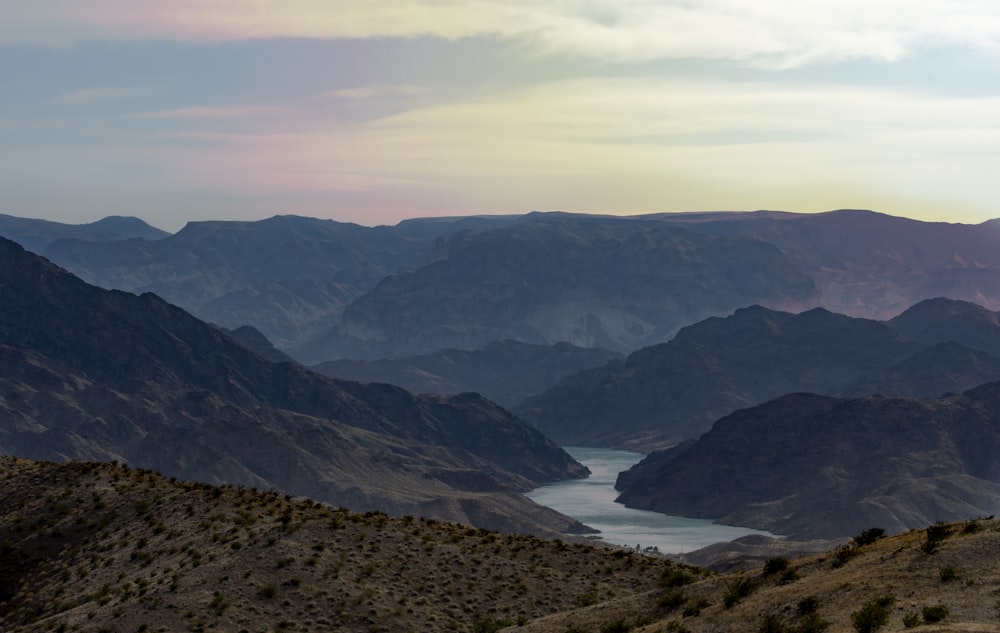 lake in the middle of mountains during daytime