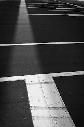 A clean, freshly painted parking lot showcasing crisp white and safety yellow lines on dark asphalt.