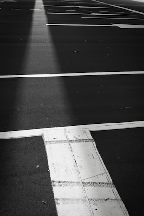 A freshly paved parking lot under bright daylight, showing smooth black asphalt surface.