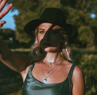 woman in green tank top wearing black hat