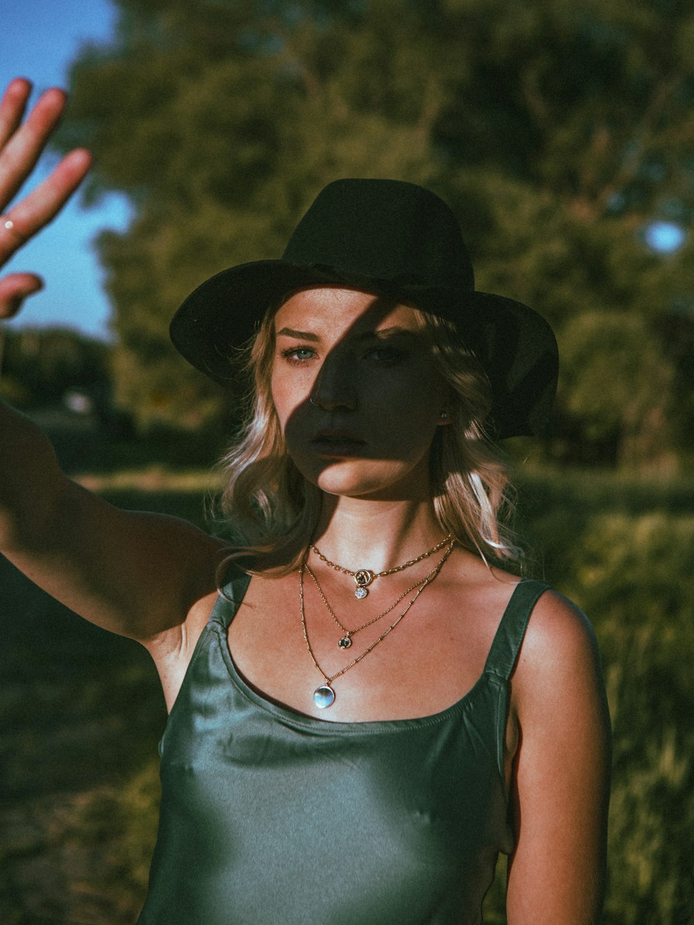 woman in green tank top wearing black hat