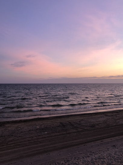 A bright, airy beach scene with soft pastel tones reflecting a feminine and clean vibe.