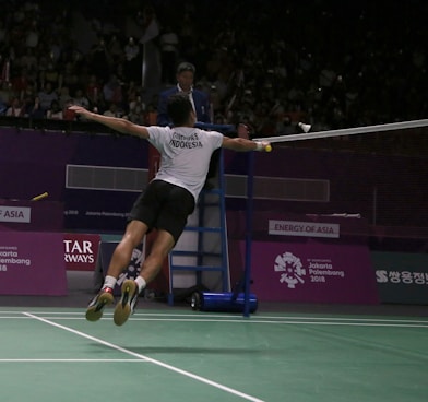 man in white t-shirt and black shorts playing tennis