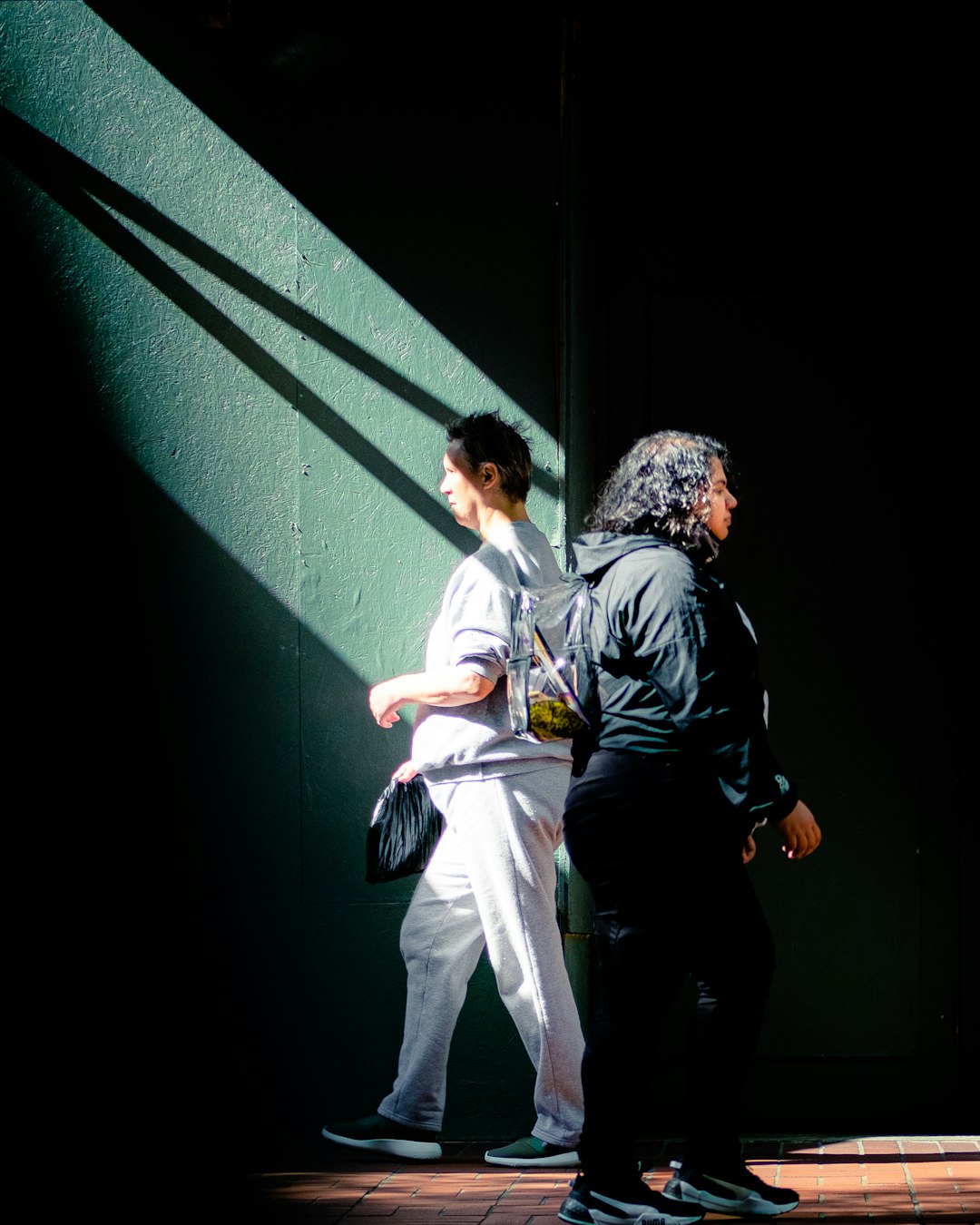 man in black jacket and white pants holding woman in white dress