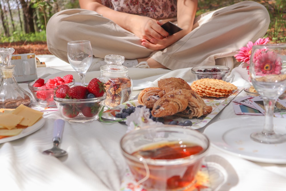 woman in white dress sitting on chair in front of table with foods